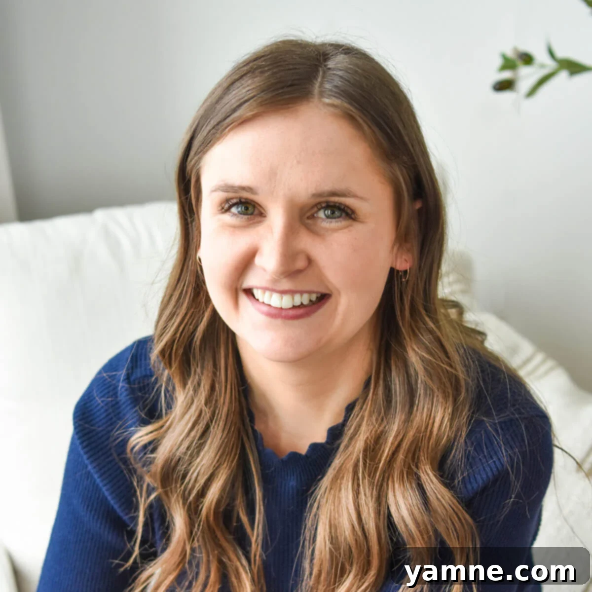 Julia Pacheco, the author, smiling, holding a cookbook.