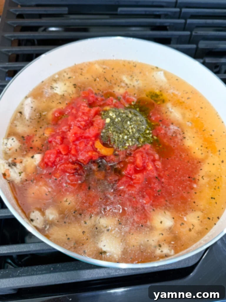 Velvety Chicken Noodle Bliss 6 A pan of creamy chicken and vegetable mixture simmering on the stovetop.