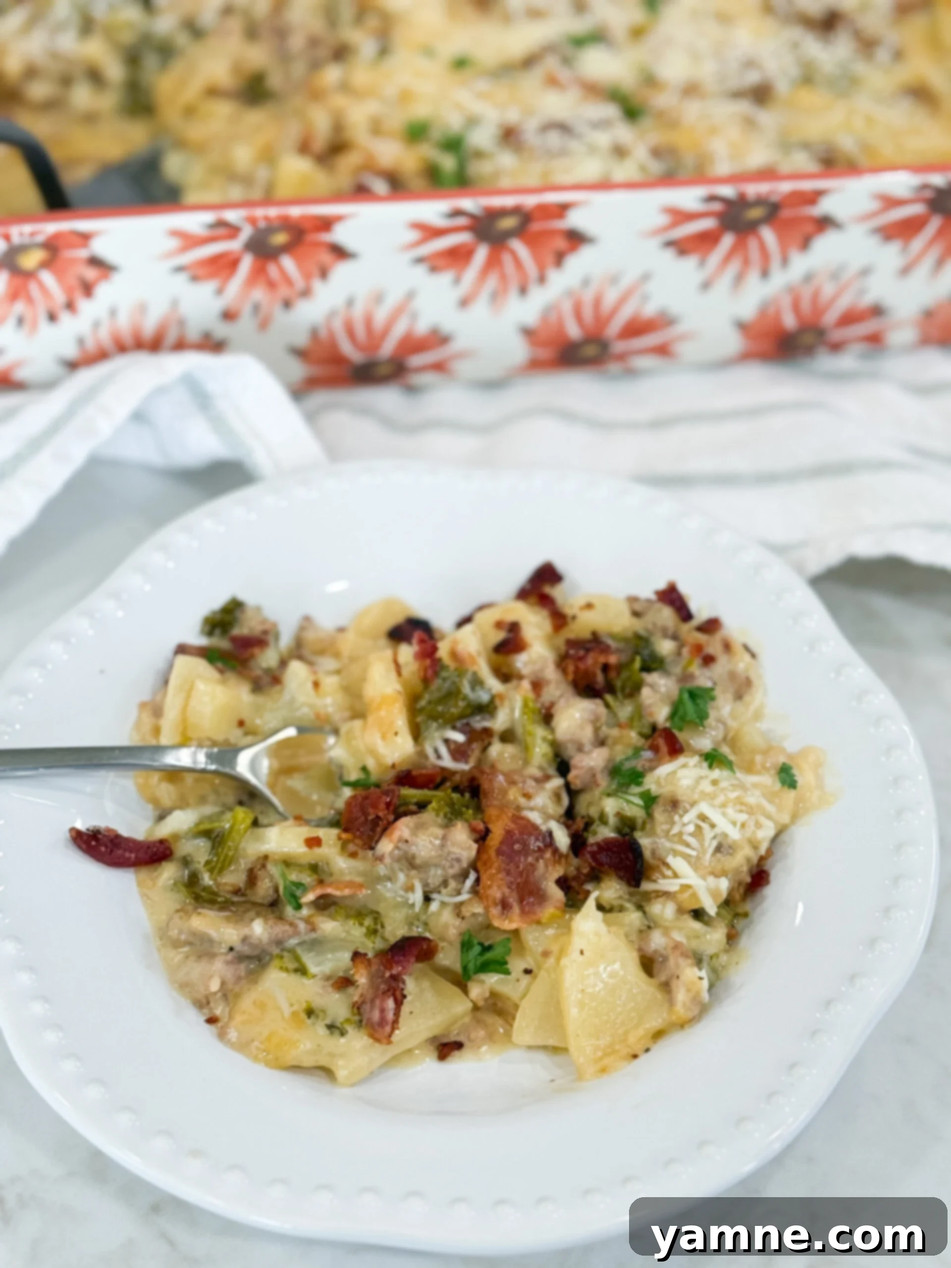 Creamy Zuppa Toscana Sausage Potato and Kale Bake 2 Serving of Zuppa Toscana Casserole plated with layers of potato, kale, sausage, bacon, and creamy sauce, garnished with fresh parsley.