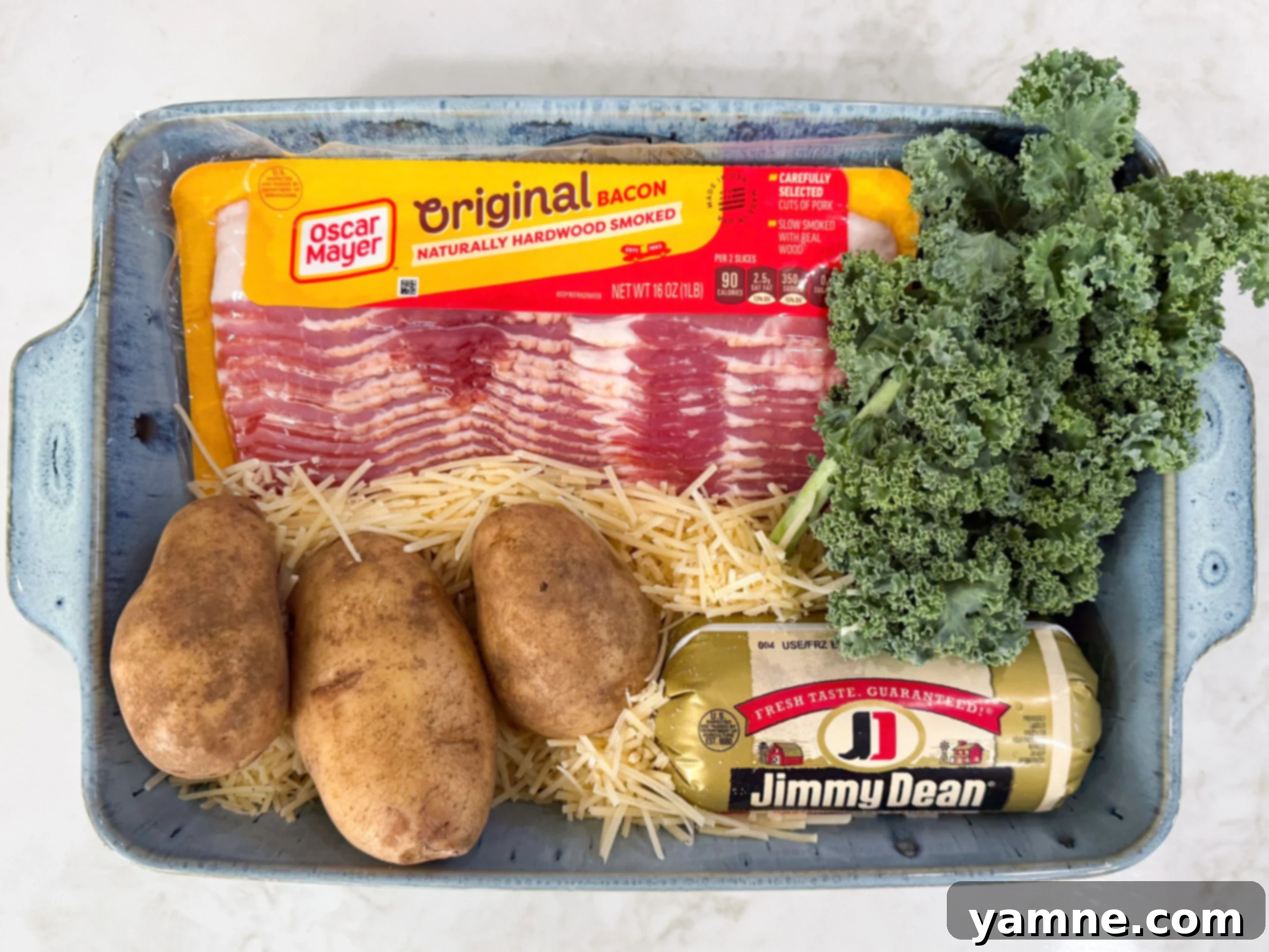Creamy Zuppa Toscana Sausage Potato and Kale Bake 4 All the ingredients for Zuppa Toscana Casserole laid out: potatoes, kale, Italian sausage, bacon, onion, garlic, heavy cream, chicken broth, and grated Parmesan cheese.