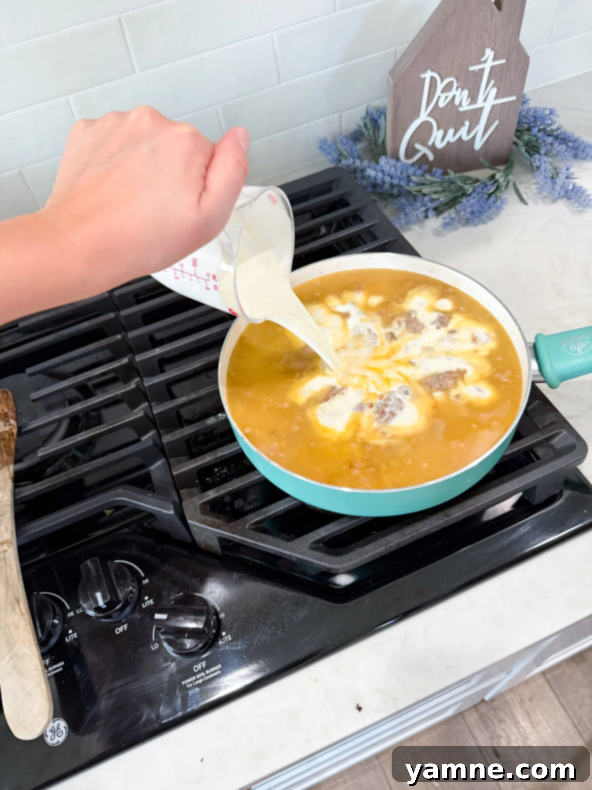 Creamy Zuppa Toscana Sausage Potato and Kale Bake 7 Creamy sauce made with flour, broth, and heavy cream simmering in a skillet with the cooked sausage and onion mixture.