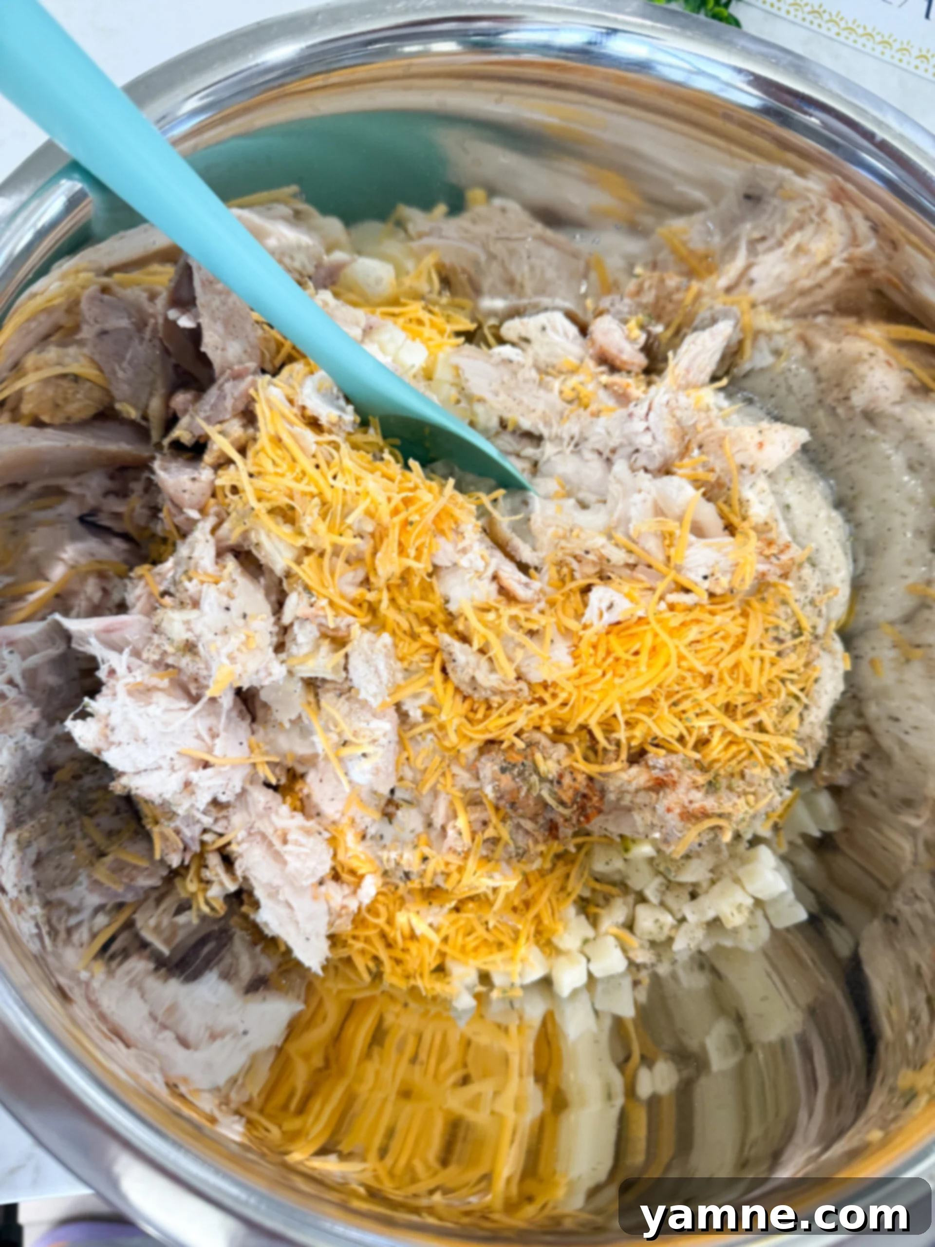 Cheesy French Onion Chicken Hash Brown Bake 5 Shredded chicken, hash browns, soup, onion dip, cheese, and seasonings mixed together in a large bowl.