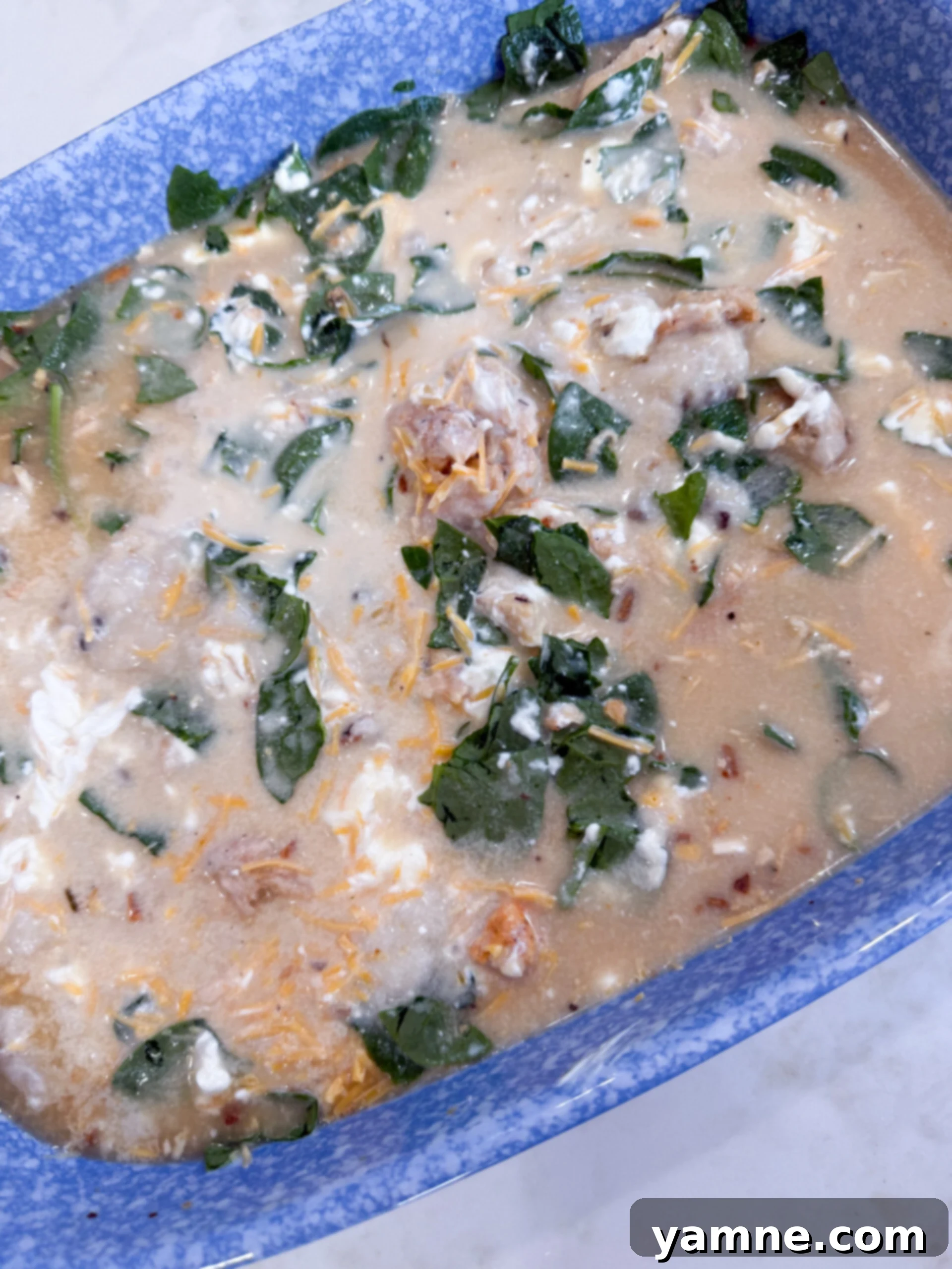 Mixing Spinach Chicken Orzo Casserole ingredients