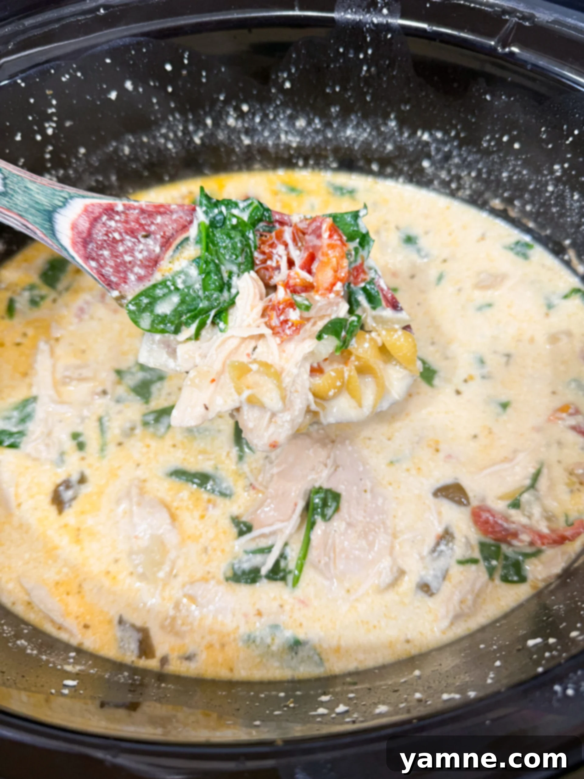 Pasta and spinach being stirred into the creamy Marry Me Chicken Soup.