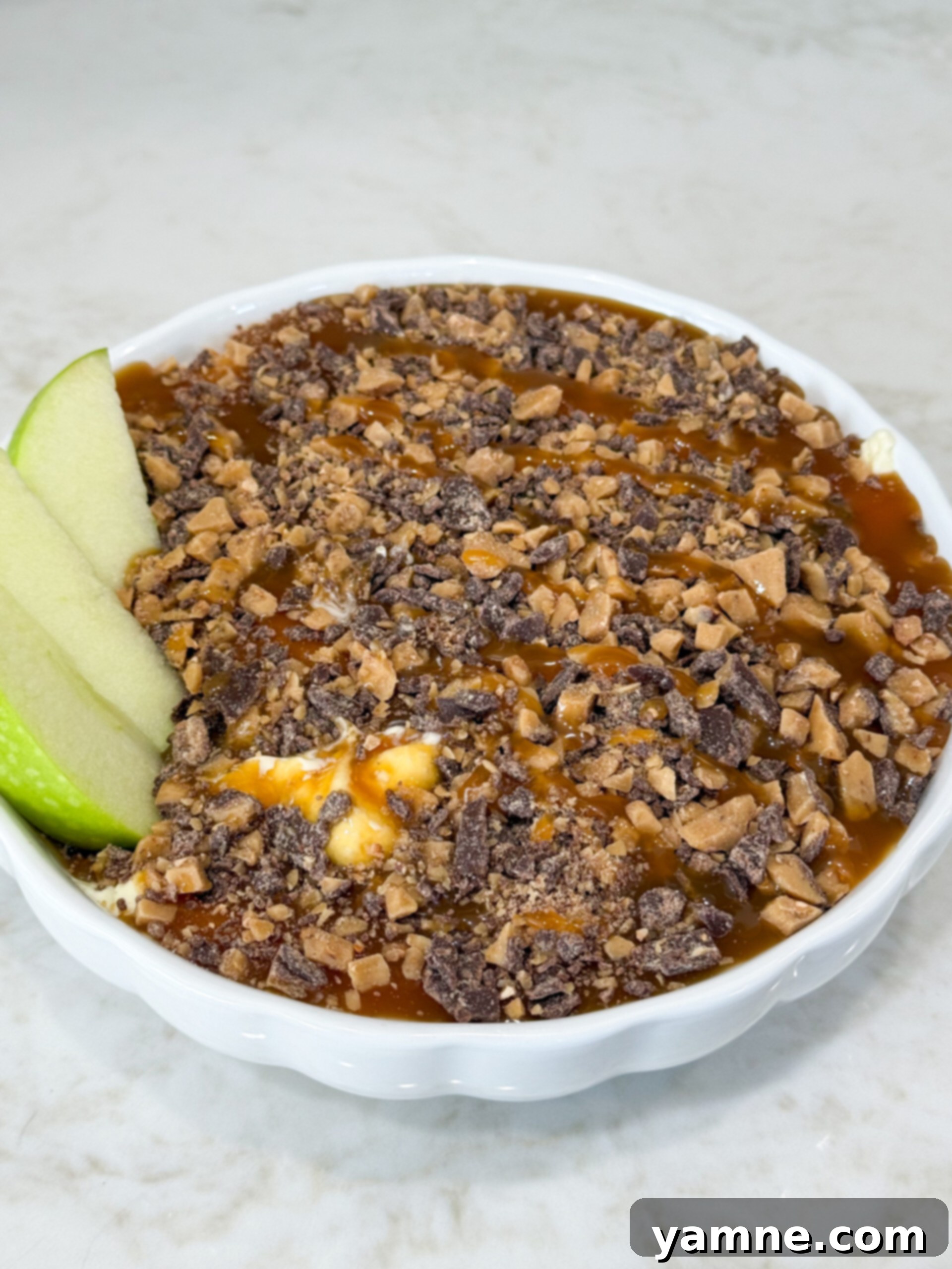 8 Magical 3-Ingredient Recipes for Easy Dinners and Delicious Treats 6 Caramel Heath cheesecake dessert dip topped with toffee bits, served with apple slices.
