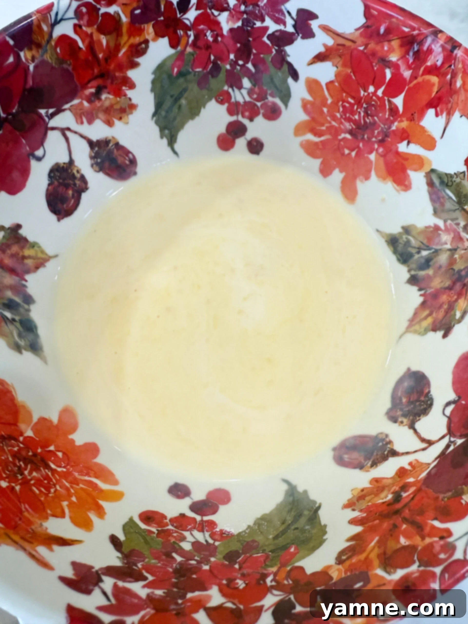 Flaky Cheesy Chicken and Broccoli Bake 8 Cream of chicken soup and milk being whisked together in a bowl to create a smooth, creamy sauce.