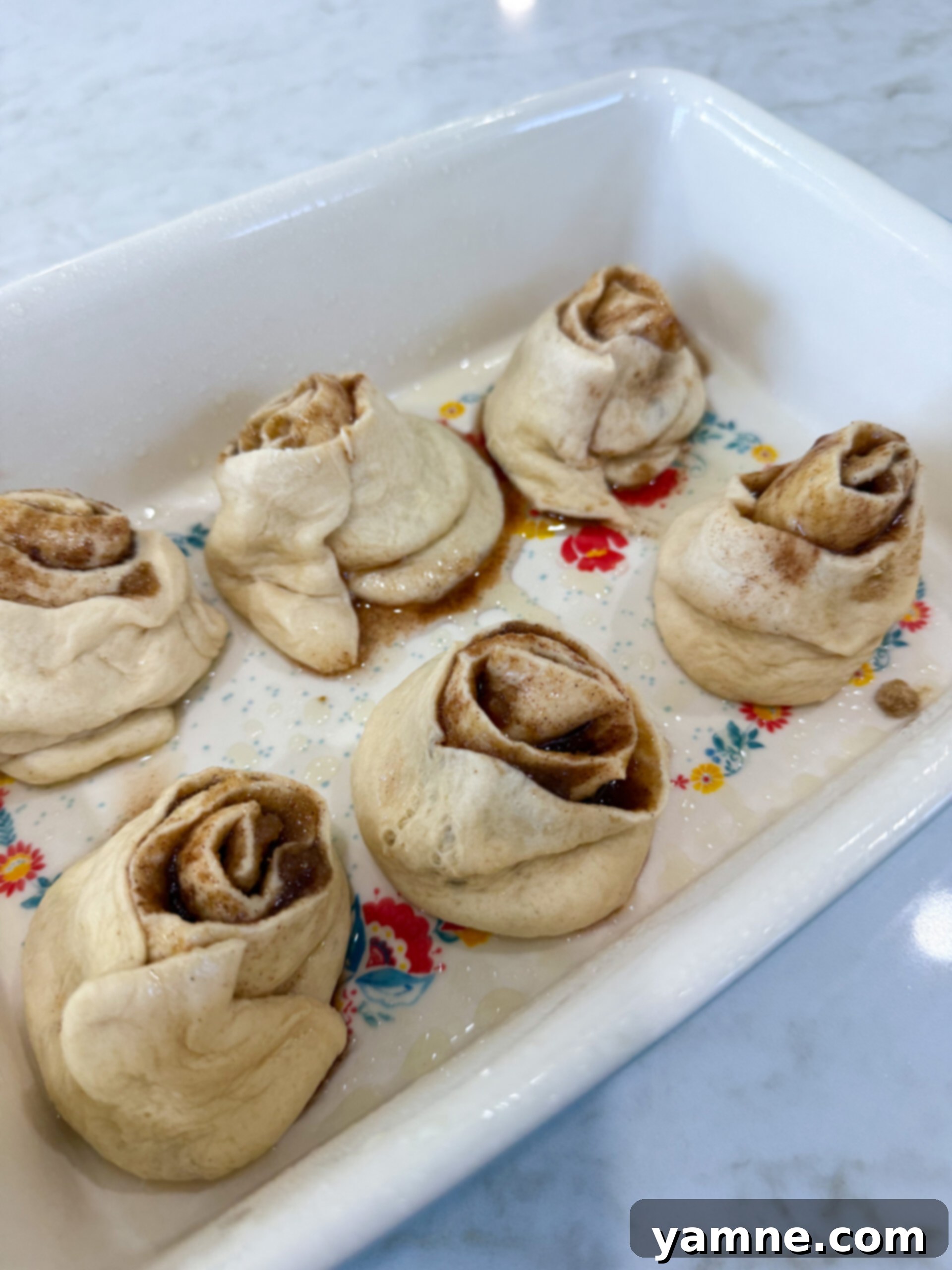 Sliced crescent roll cinnamon rolls in a baking dish ready for the oven