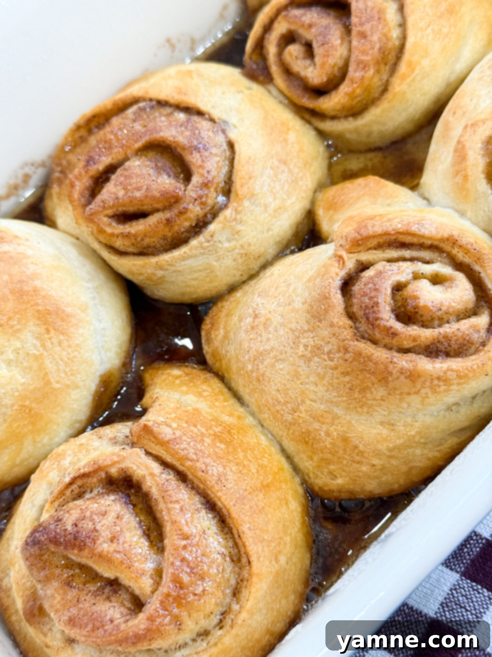 Crescent roll cinnamon rolls baking in a pan