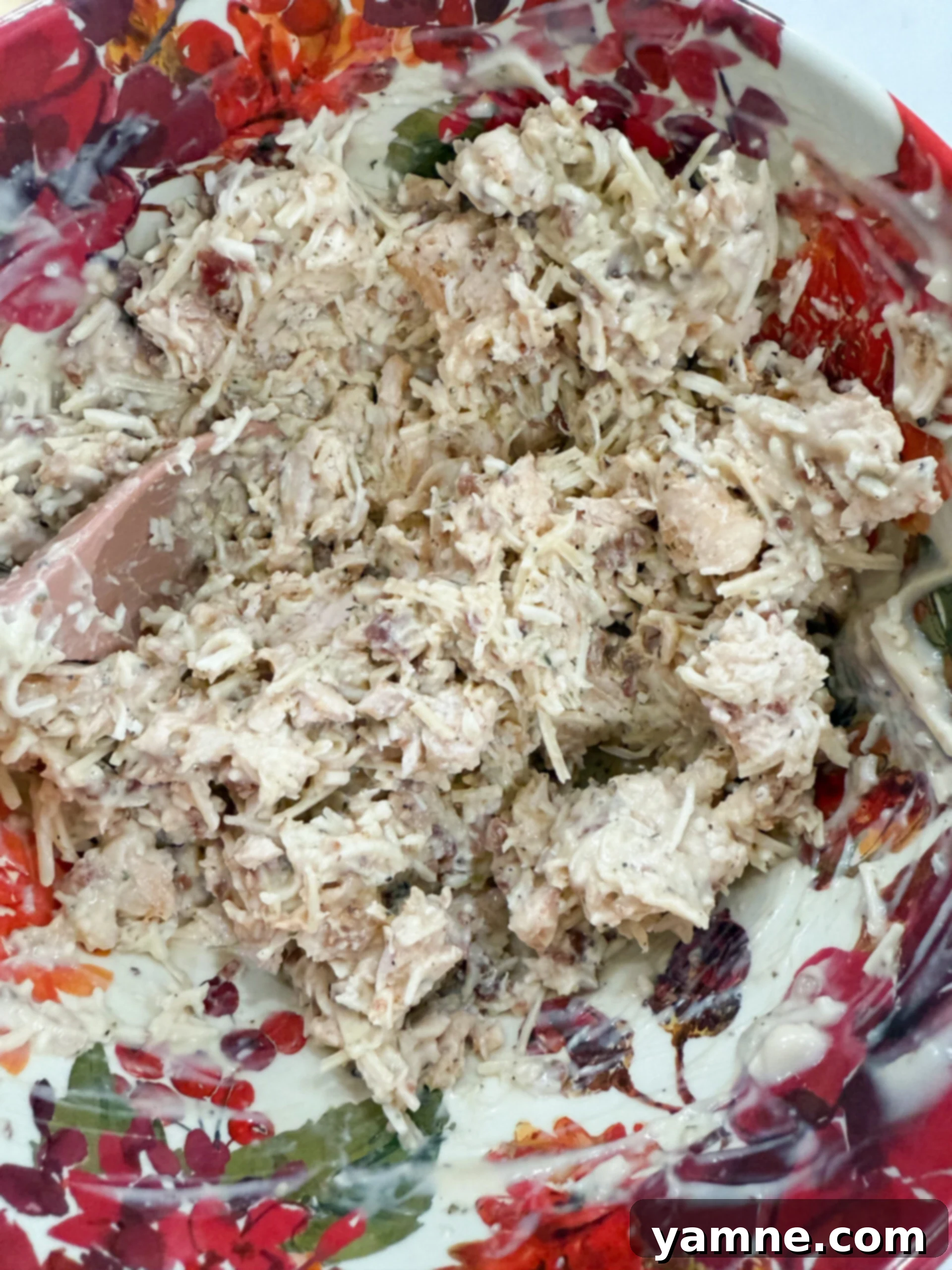 Chicken, Alfredo sauce, bacon, seasonings, Parmesan, and mozzarella are mixed in a large bowl, creating the delicious filling for the crescent ring.