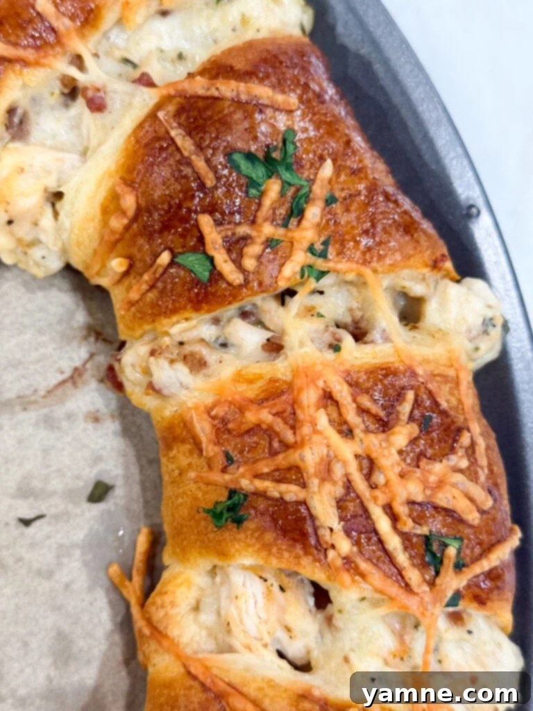 A freshly baked, golden-brown Bacon Chicken Alfredo Crescent Ring, perfectly cooked and ready to be enjoyed.