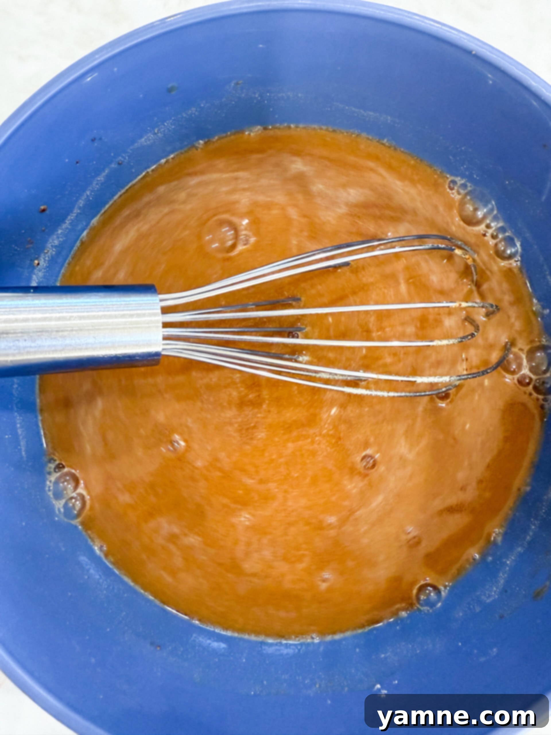 Easy Slow Cooker Beef Stroganoff 7 A bowl containing beef broth, Worcestershire sauce, minced garlic, and a packet of brown gravy mix, ready to be whisked together for the stroganoff sauce.