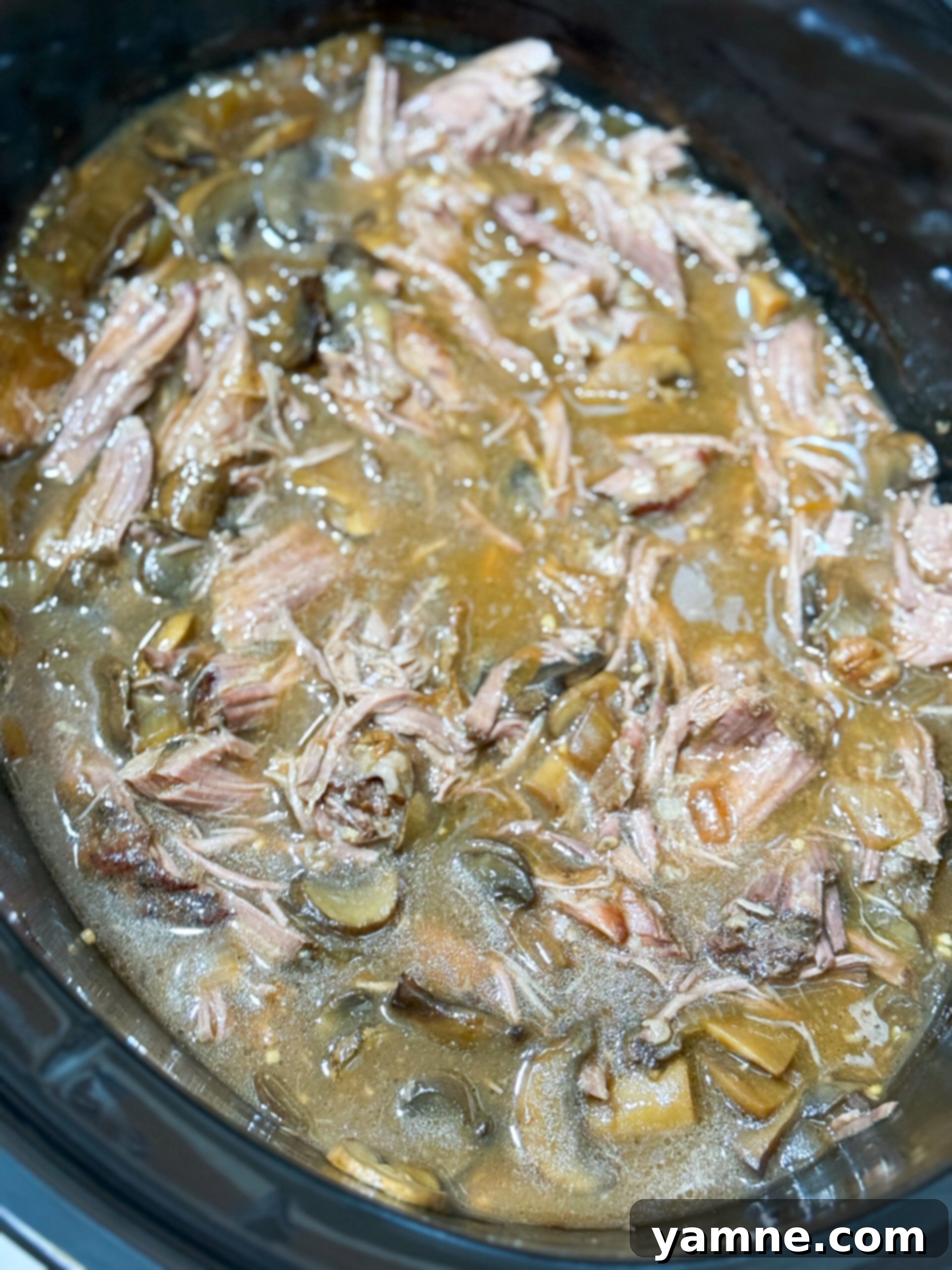 Easy Slow Cooker Beef Stroganoff 9 Beef stroganoff simmering in a slow cooker, with tender beef, mushrooms, and a rich, dark sauce.