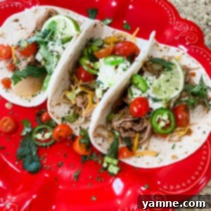Delicious slow cooker shredded pork tacos with fresh toppings like cilantro and lime