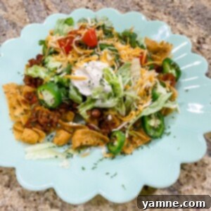 A deliciously assembled Frito Pie with chili, cheese, and fresh toppings