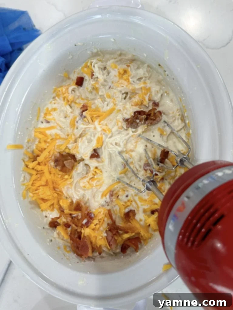 Raw chicken, chicken broth, cream cheese, and ranch seasoning in a slow cooker