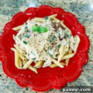 Creamy Tuscan Alfredo Chicken with penne pasta and fresh spinach