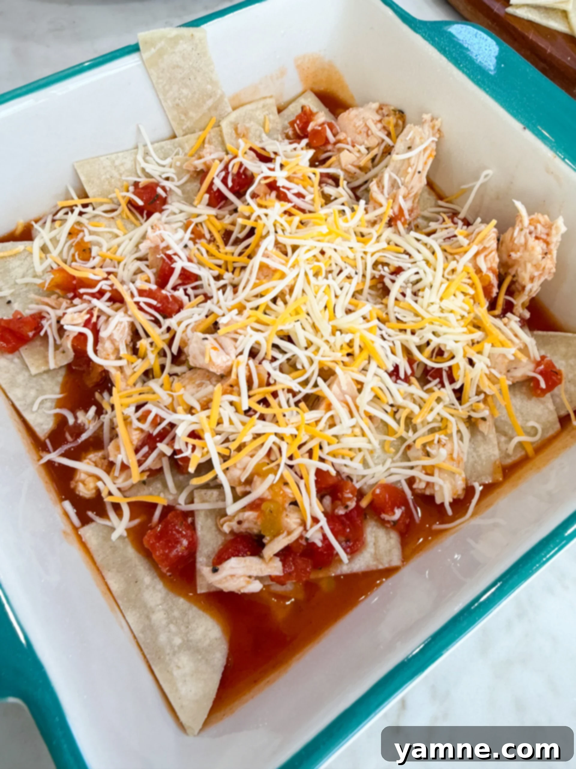 Layering Red Chili Chicken Enchiladas