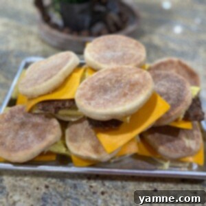 A stack of delicious homemade breakfast sandwiches with eggs, cheese, and meat on English muffins
