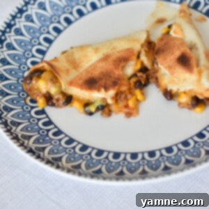 A top-down view of a giant sheet pan loaded quesadilla, showcasing the golden tortillas and a glimpse of the cheesy filling.