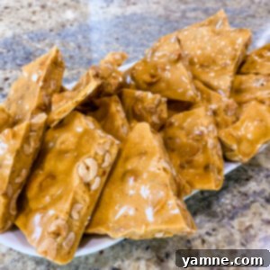 Delicious and crunchy microwave peanut brittle on a festive plate, ready to be enjoyed.