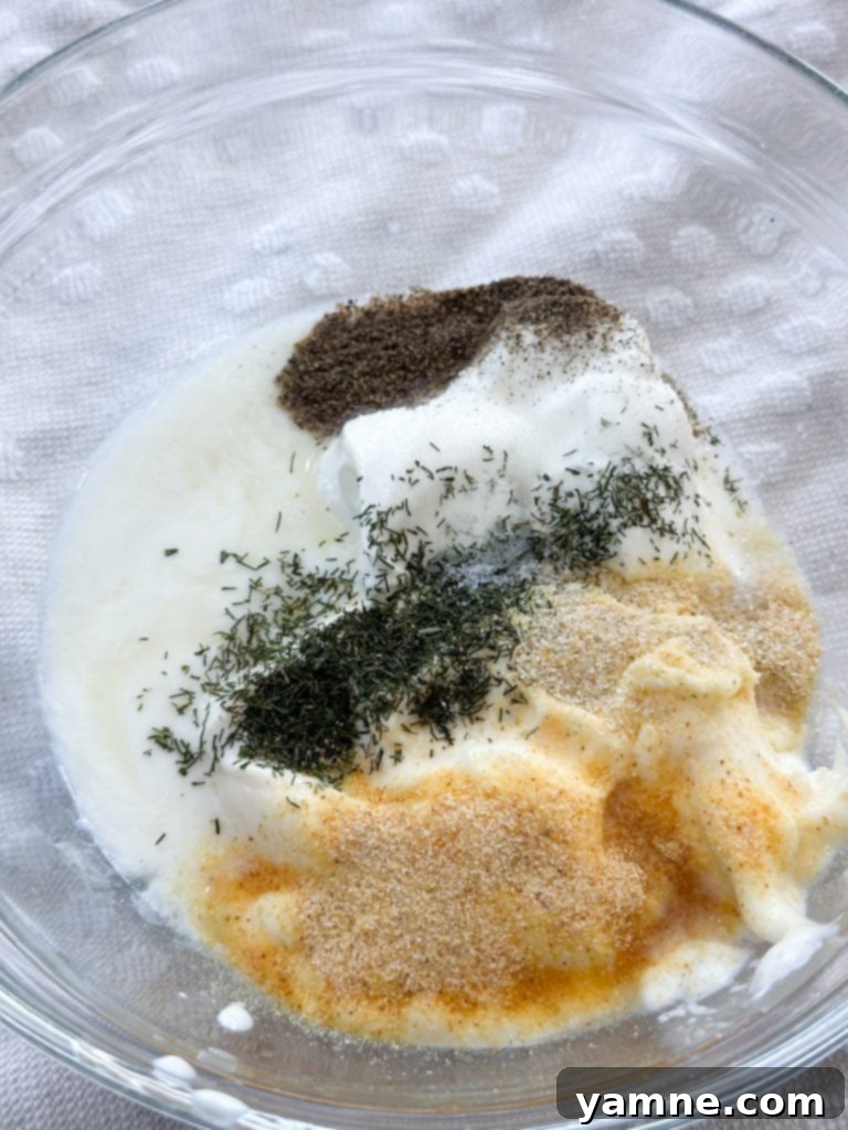 A bowl of freshly mixed creamy ranch dressing, ready to be combined with pasta and vegetables for the ranch bacon pasta salad.