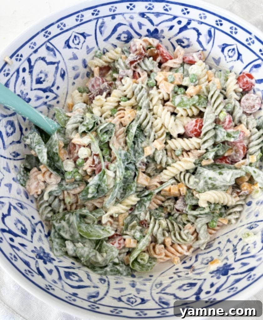 A large bowl of finished creamy ranch bacon pasta salad, mixed and chilled, ready to be served at a gathering.