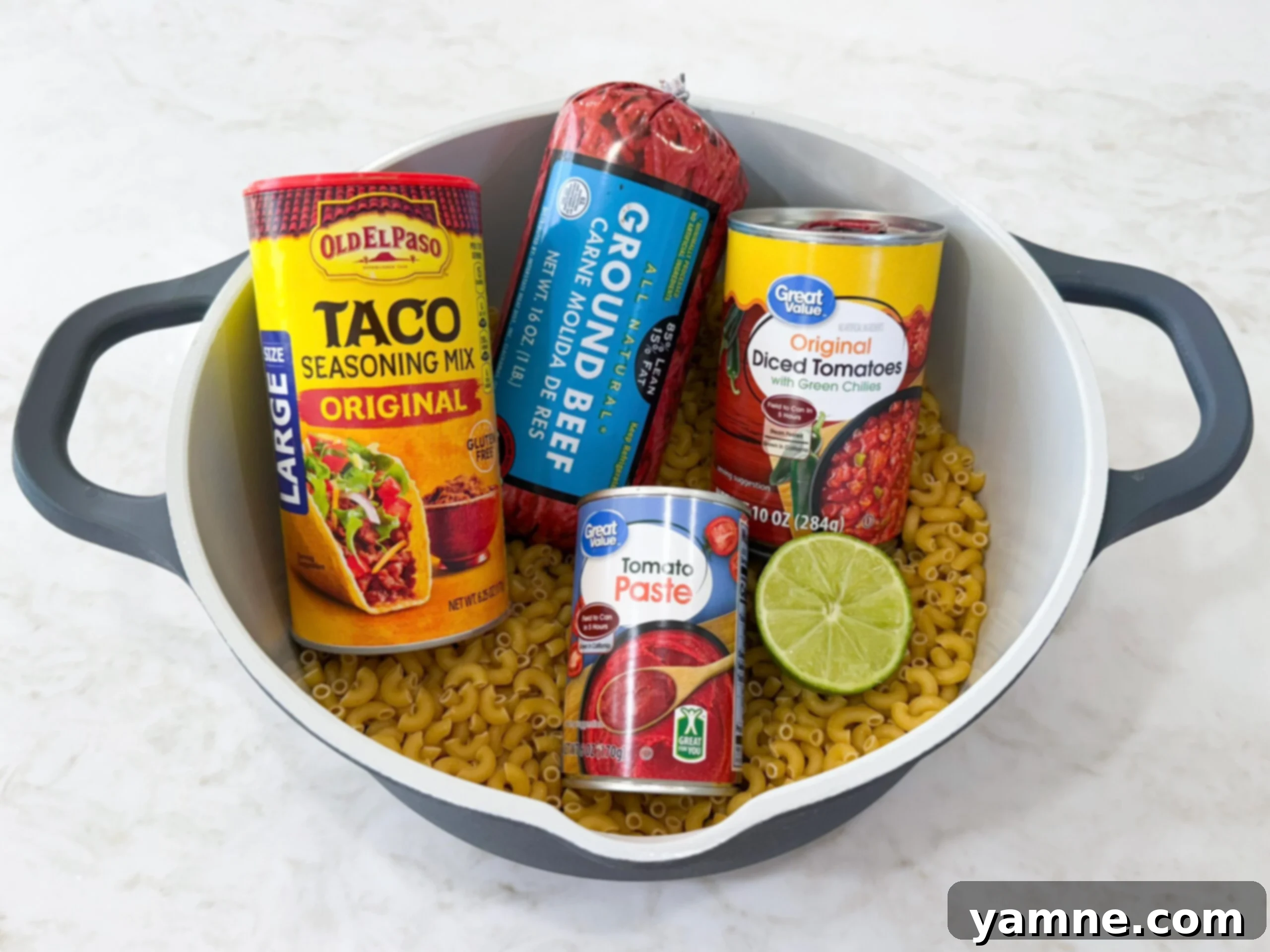 Easy Taco Pasta One Pot Skillet Dinner ingredients laid out on a counter next to a pot.