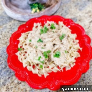 Delicious Slow Cooker Italian Creamy Chicken served over pasta.