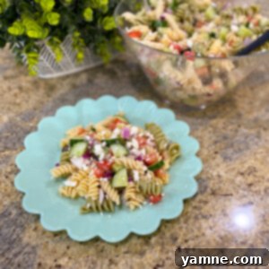 A vibrant bowl of Greek Pasta Salad with rotini pasta, fresh vegetables, and feta cheese.