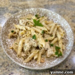 Delicious Creamy Pesto Chicken Pasta served in a bowl, garnished with fresh basil