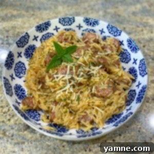 Delicious one-pan smoked sausage and orzo pasta dish, garnished with fresh parsley.