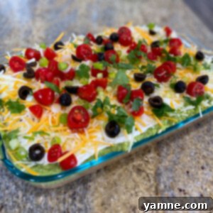 Five Layer Taco Dip 2 Delicious 5-Layer Taco Dip garnished with fresh toppings and ready to serve with tortilla chips.