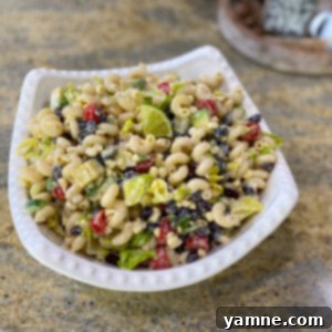 Vibrant Taco Pasta Salad with spiral pasta, corn, black beans, tomatoes, and avocado, tossed in a zesty, creamy dressing, ready to be served.