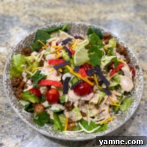 A bowl of creamy, orange-hued Southwest Dressing, garnished with fresh cilantro, ready to be served.