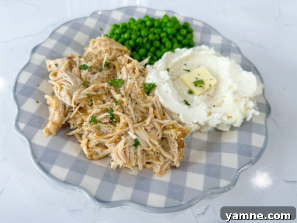 shredded slow cooker chicken and gravy in a serving bowl