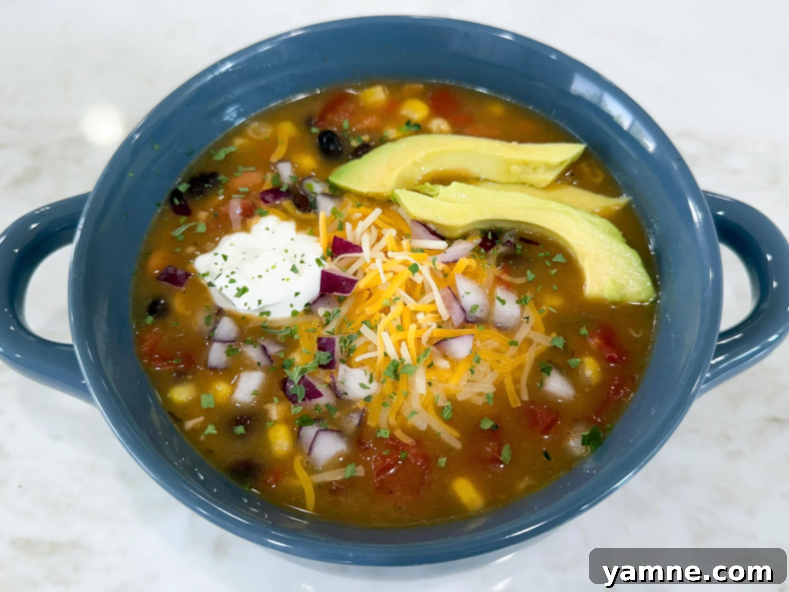 Bowl of 8 Can Chicken Taco Soup topped with sour cream and cheese