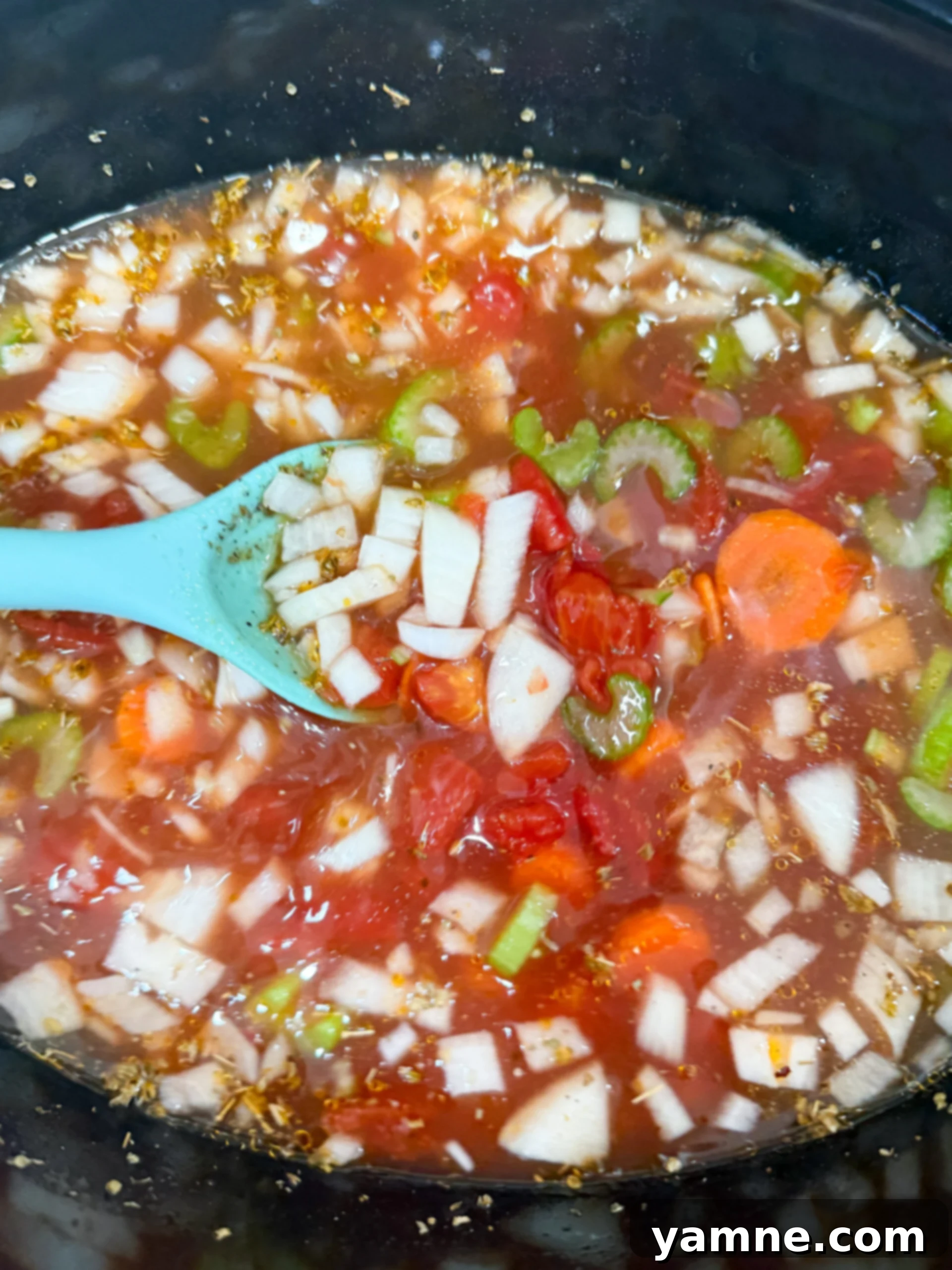 Adding vegetables and broth to slow cooker for minestrone