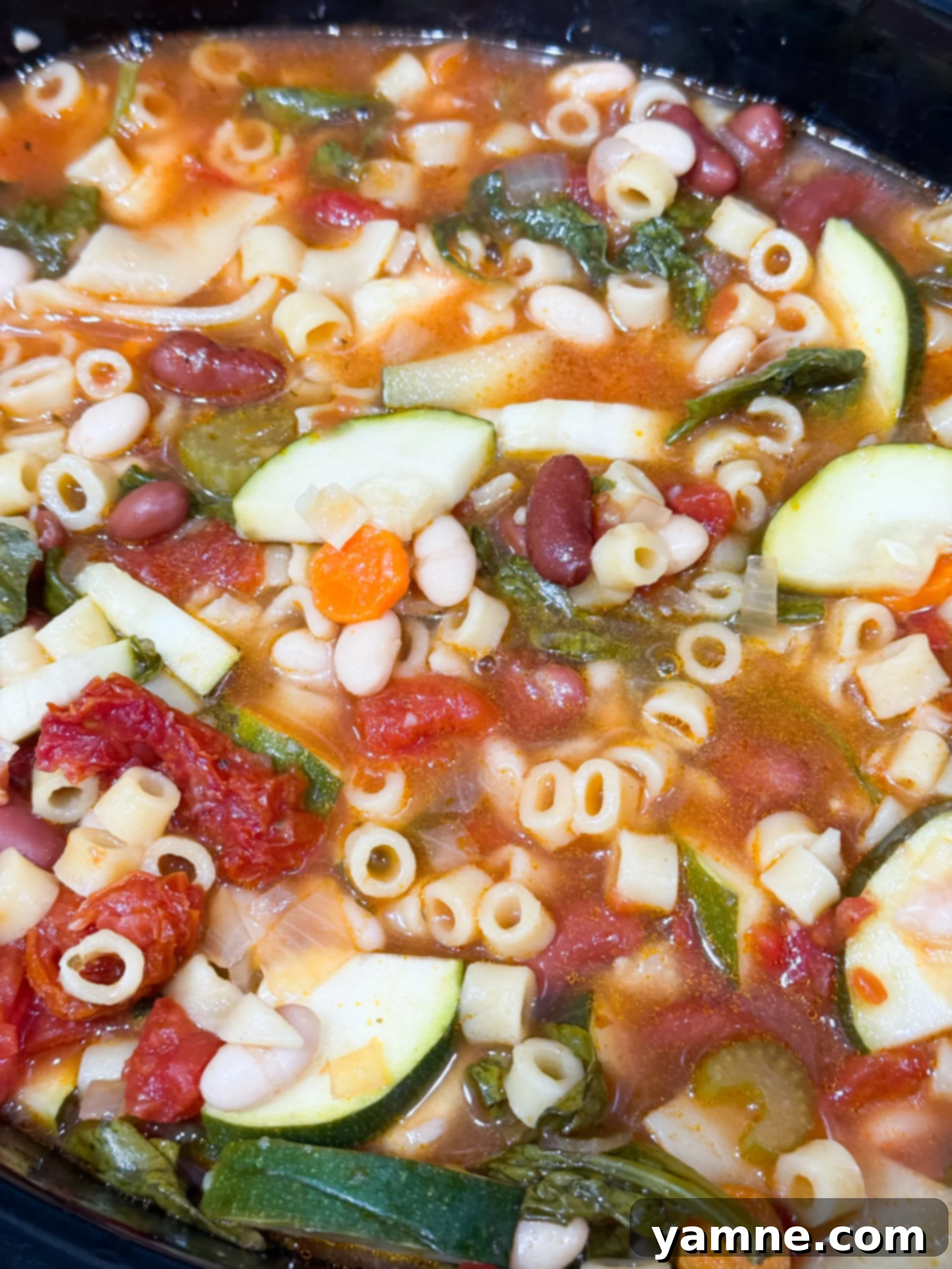 Minestrone soup in slow cooker with vegetables and pasta