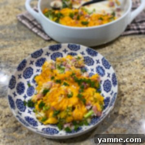 A delicious creamy ham, broccoli, and cauliflower casserole in a baking dish, topped with melted cheese, ready to be served.
