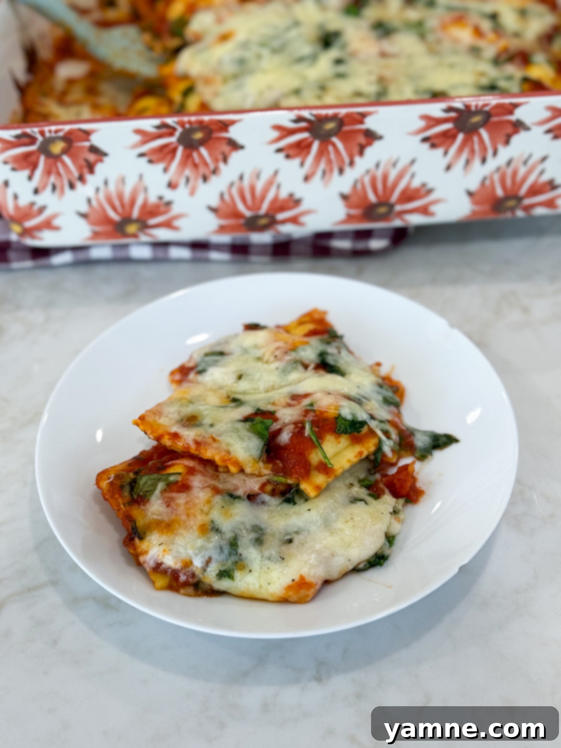 Cheesy Ravioli Casserole 2 Simple cheese ravioli bake on a plate topped with melted mozzarella and herbs