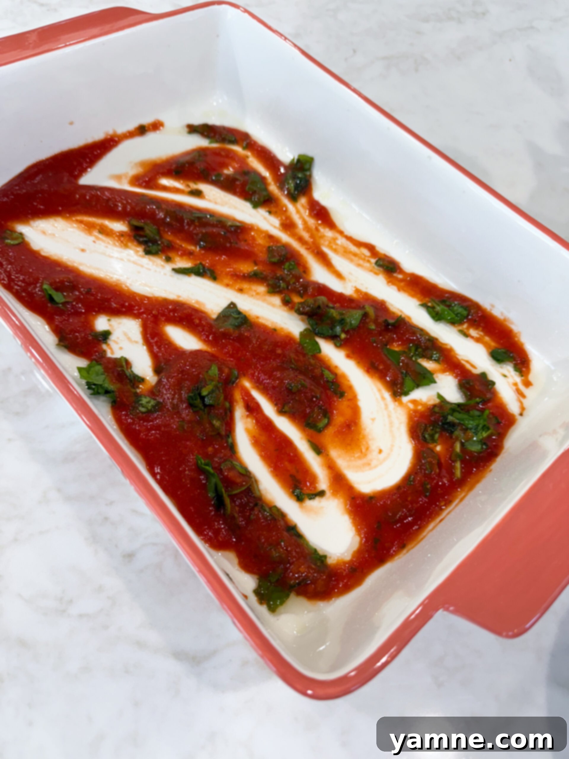 Cheesy Ravioli Casserole 6 Marinara sauce and spinach spread on the bottom of baking dish