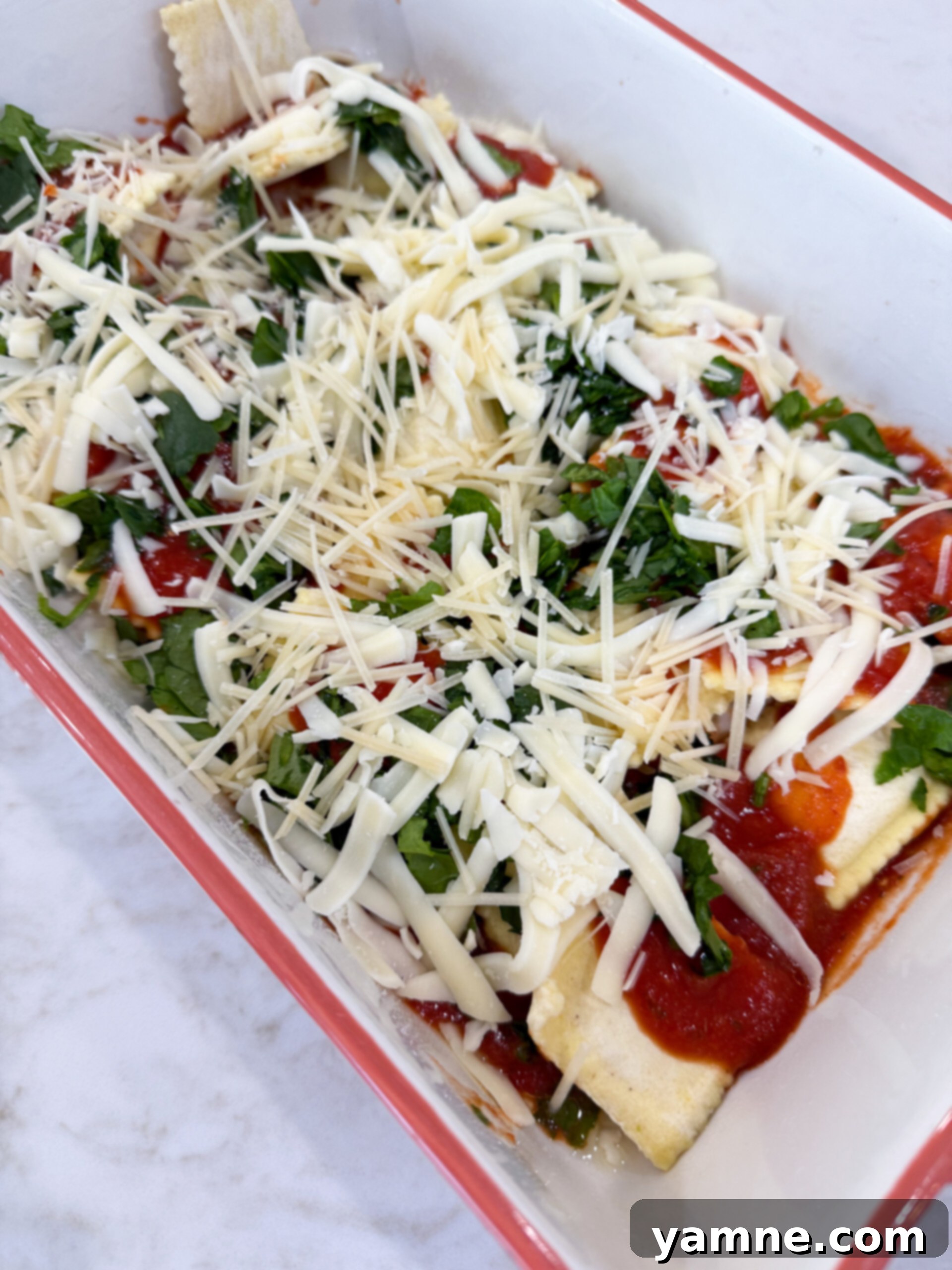 Cheesy Ravioli Casserole 7 Layering ravioli, sauce, and cheese in baking dish