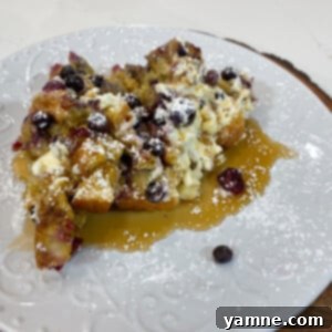 Delicious Slow Cooker Blueberry Cream Cheese French Toast Casserole topped with powdered sugar and maple syrup