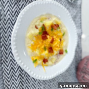 Comforting Potato Soup 2 Delicious bowl of creamy loaded baked potato soup garnished with bacon, cheese, and green onions.