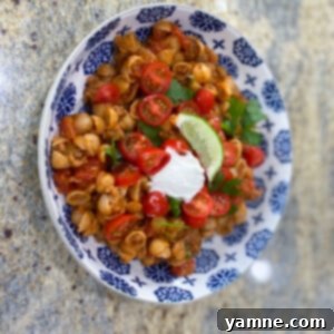 A deliciously creamy bowl of Taco Mac and Cheese, garnished with fresh cilantro and a sprinkle of cheese, ready to be enjoyed.