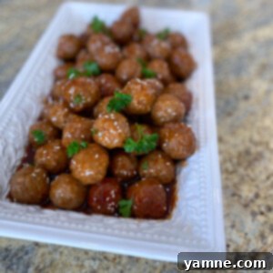 Easy Honey BBQ Slow Cooker Meatballs 2 Delicious Honey BBQ Slow Cooker Meatballs coated in sweet and tangy sauce, garnished with parsley and sesame seeds